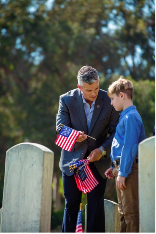 Still from the Scottish Rite, NMJ’s video Crafting Our Story, showing a member handing an American flag to a young boy